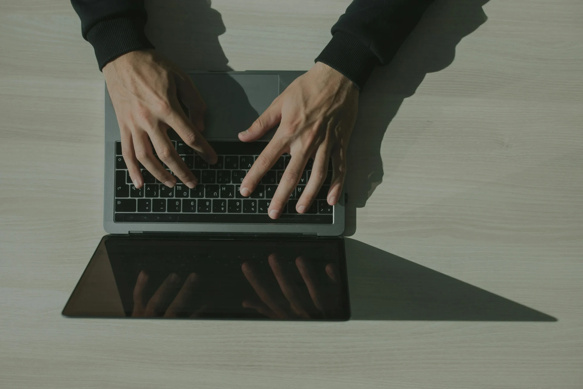 Close-up of hands typing on a laptop keyboard while implementing UX web design basics.