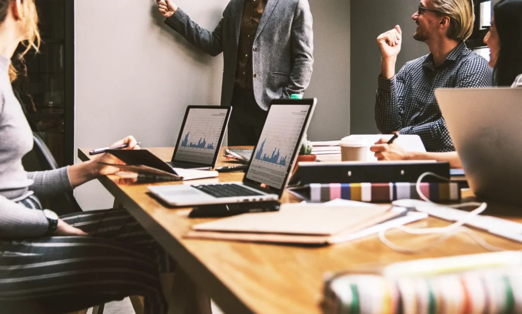 Group of social media marketing specialists examining metrics on digital screens