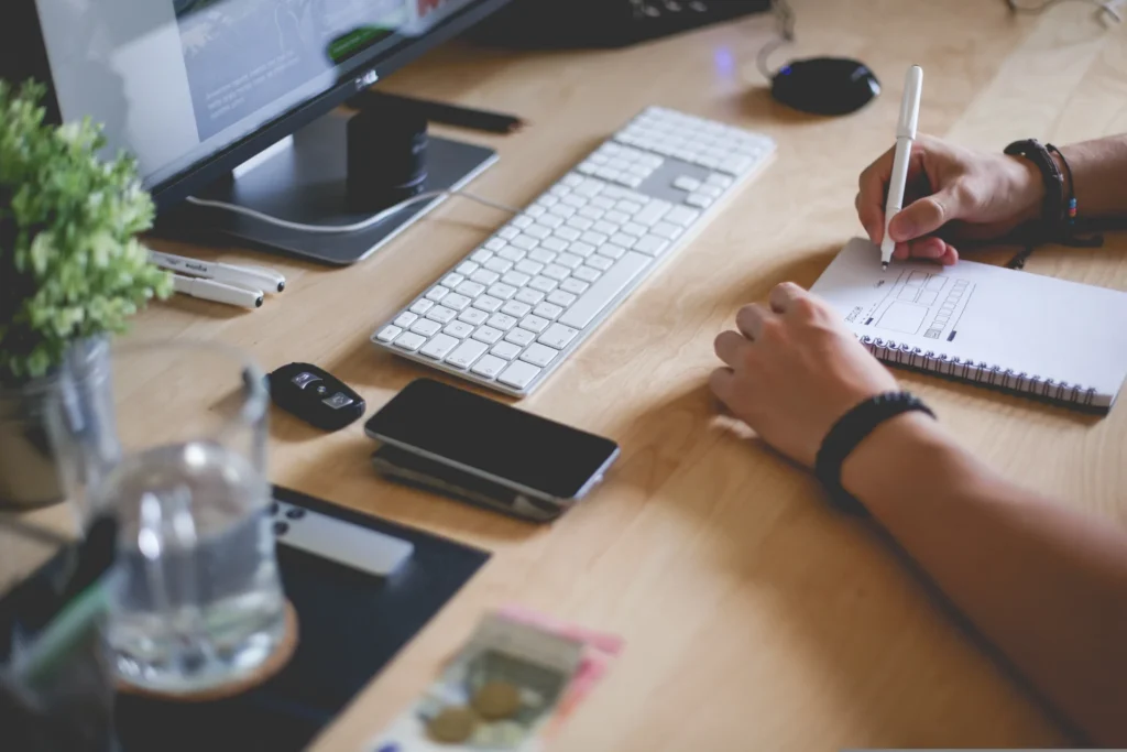 Person planning content strategy at a desk with computer and notepad