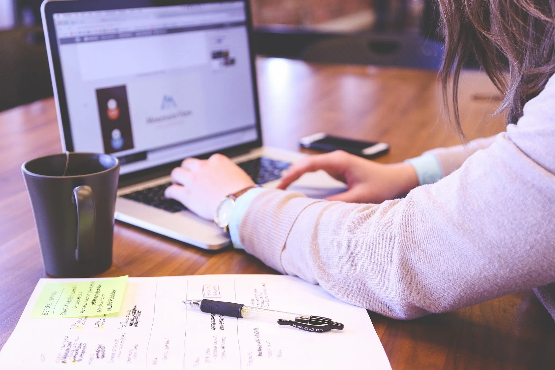 Woman working on laptop, conducting broken link building research.