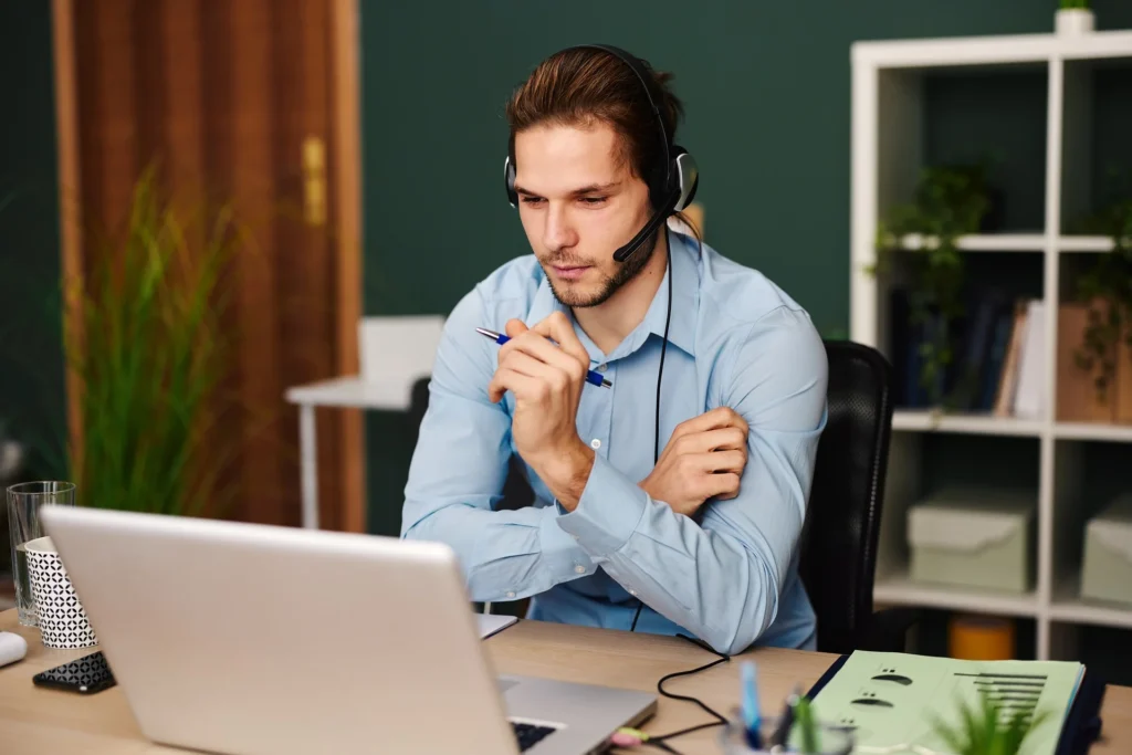 Man with headset working on a laptop, representing social media marketing strategies