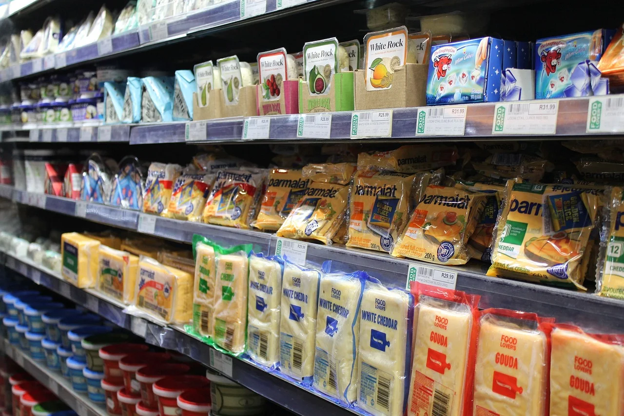 A variety of cheese products displayed on supermarket shelves. This image showcases the potential for digital marketing solutions to promote CPG brands in the grocery industry.