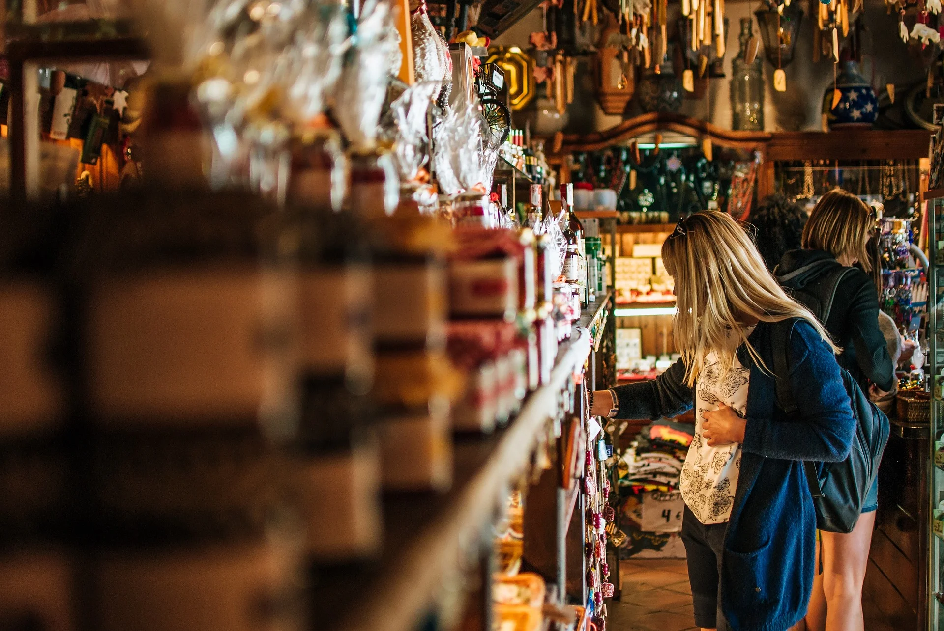 Customer examining CPG merchandise on a store shelf, considering purchase.