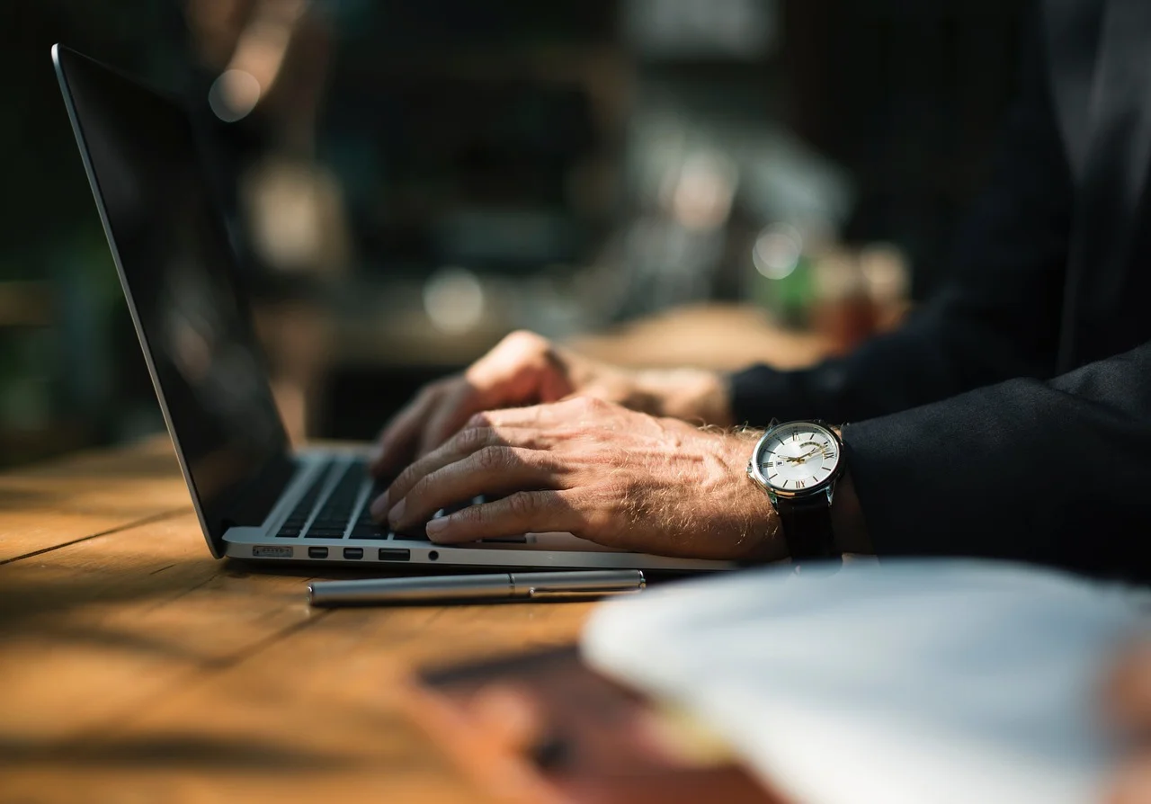 Person working on a laptop, focused on digital marketing solutions.