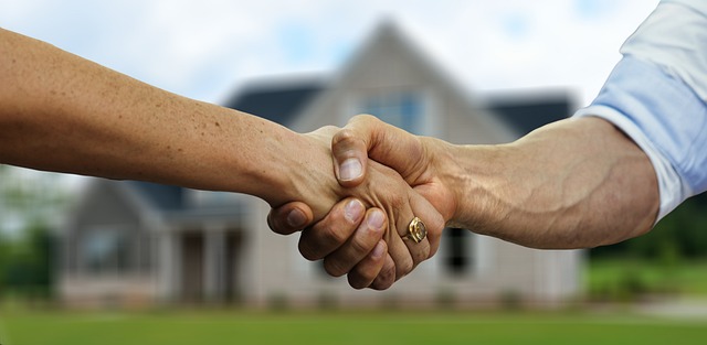 A handshake between a real estate agent and a client, showcasing the power of building relationships through social media marketing.