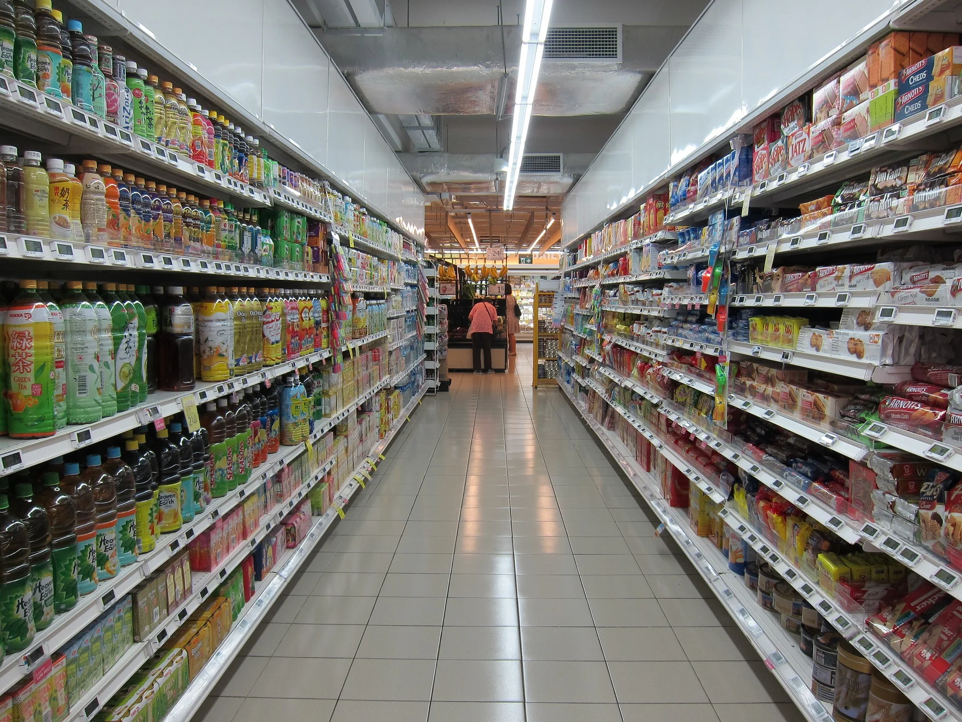 Well-stocked supermarket aisle with various consumer packaged goods.