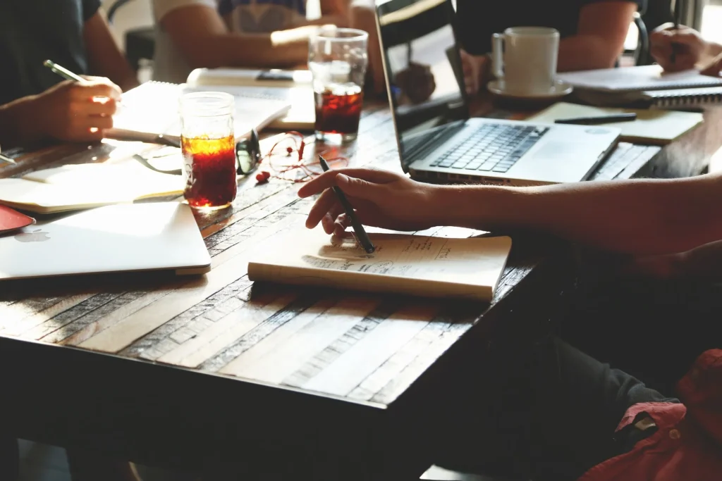 A group of people working together at a table, discussing b2b marketing KPIs.