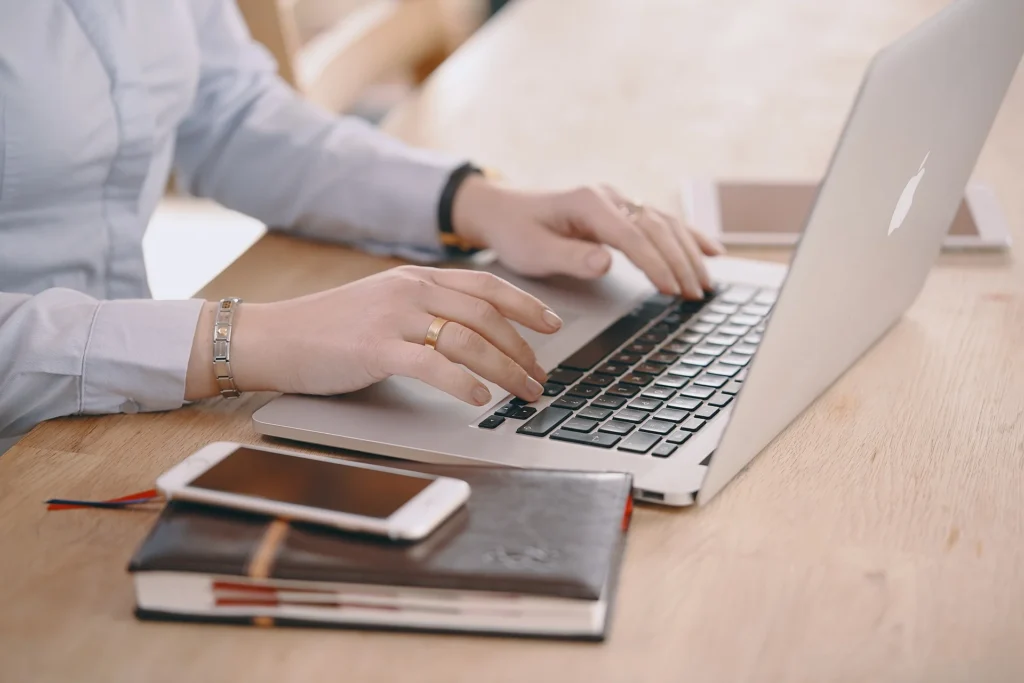 Person working on laptop, analyzing data for marketing infographics.