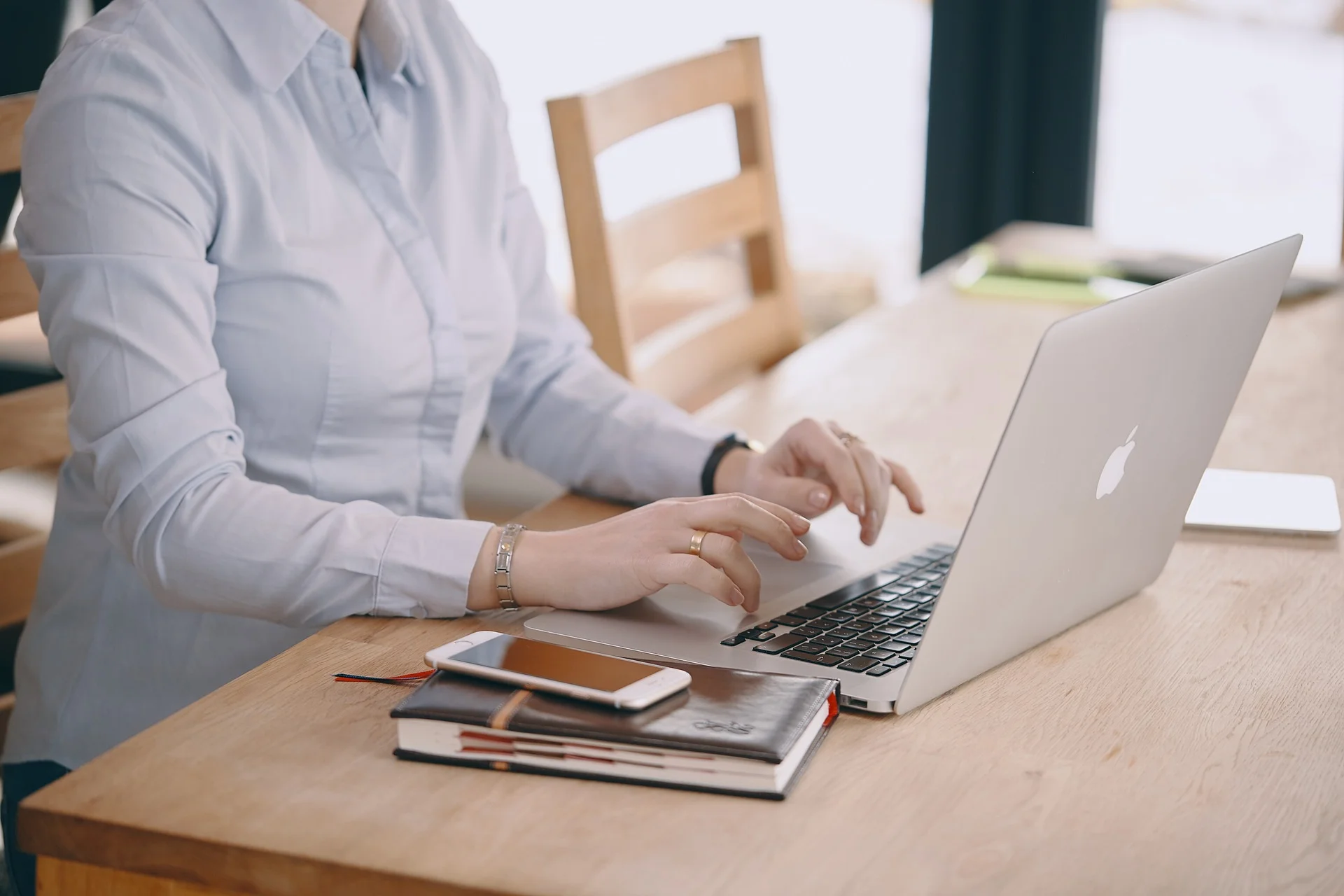 Woman using her laptop to explore UX vs. UI design concepts.