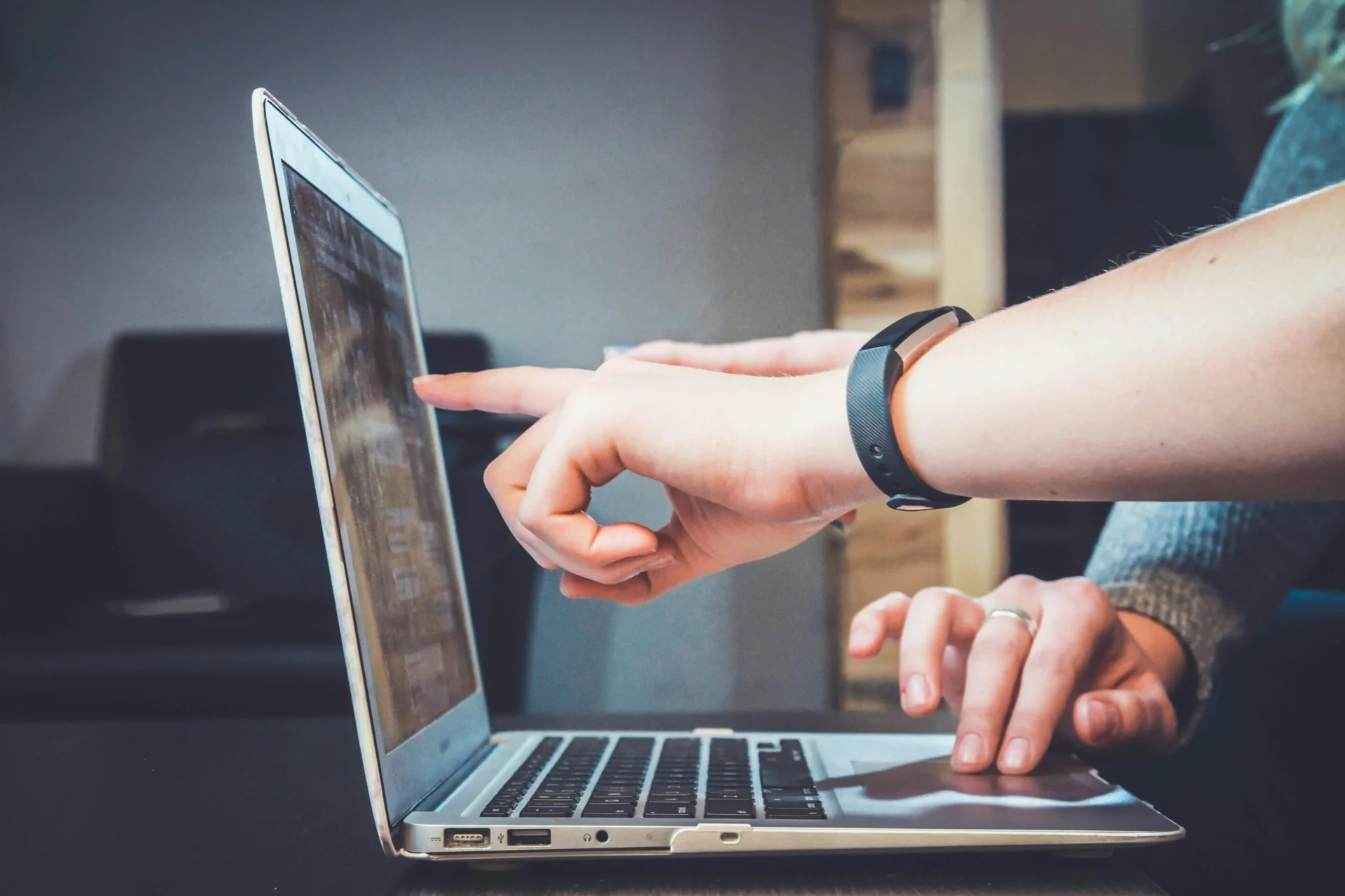 Hands pointing at a laptop screen, with a focus on SEO analysis.