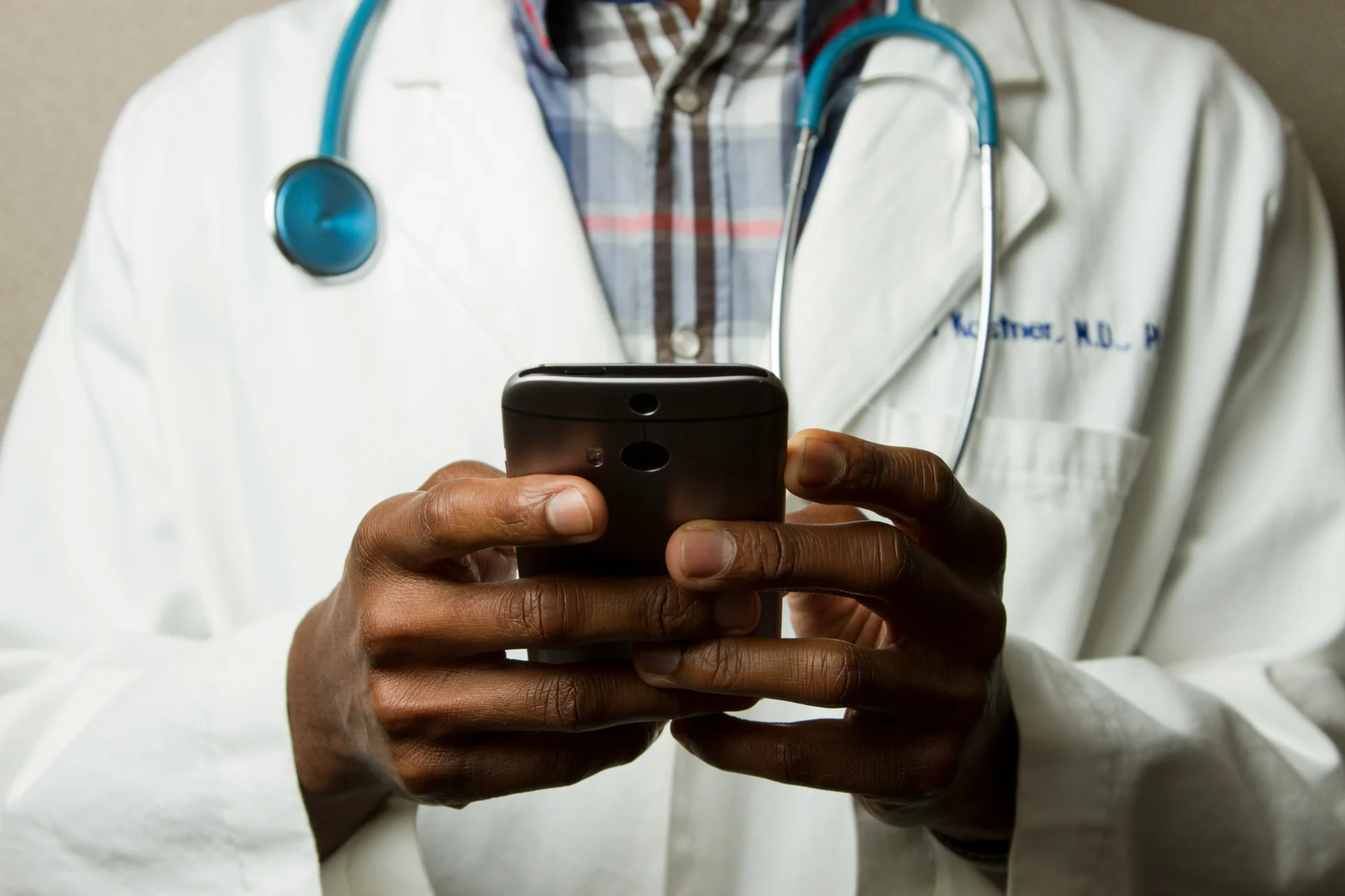 A healthcare professional uses a smartphone, representing the use of conversational AI in healthcare for improved patient communication and accessibility.