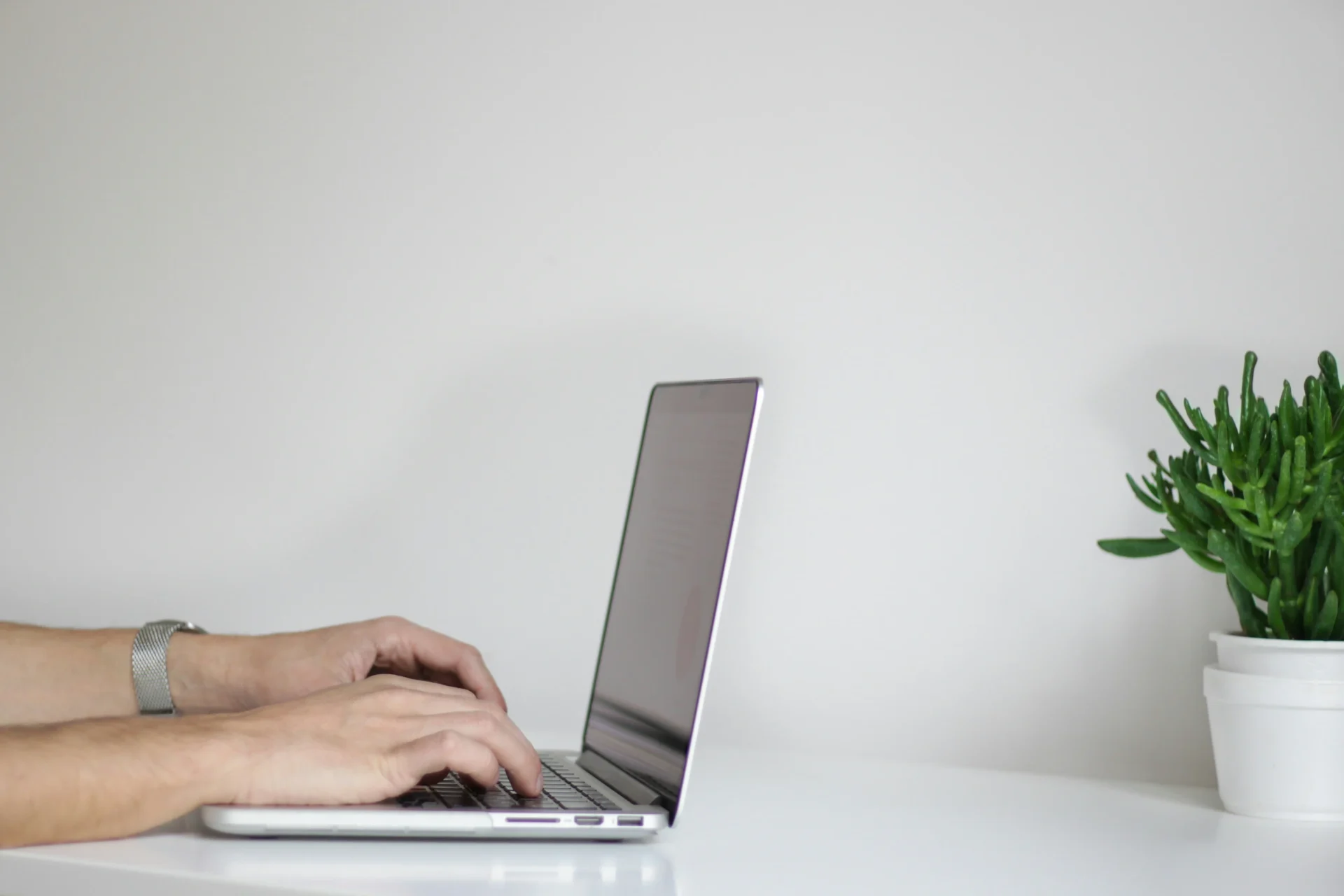 Close-up of hands typing on a laptop for Social Media Engagement Strategy development