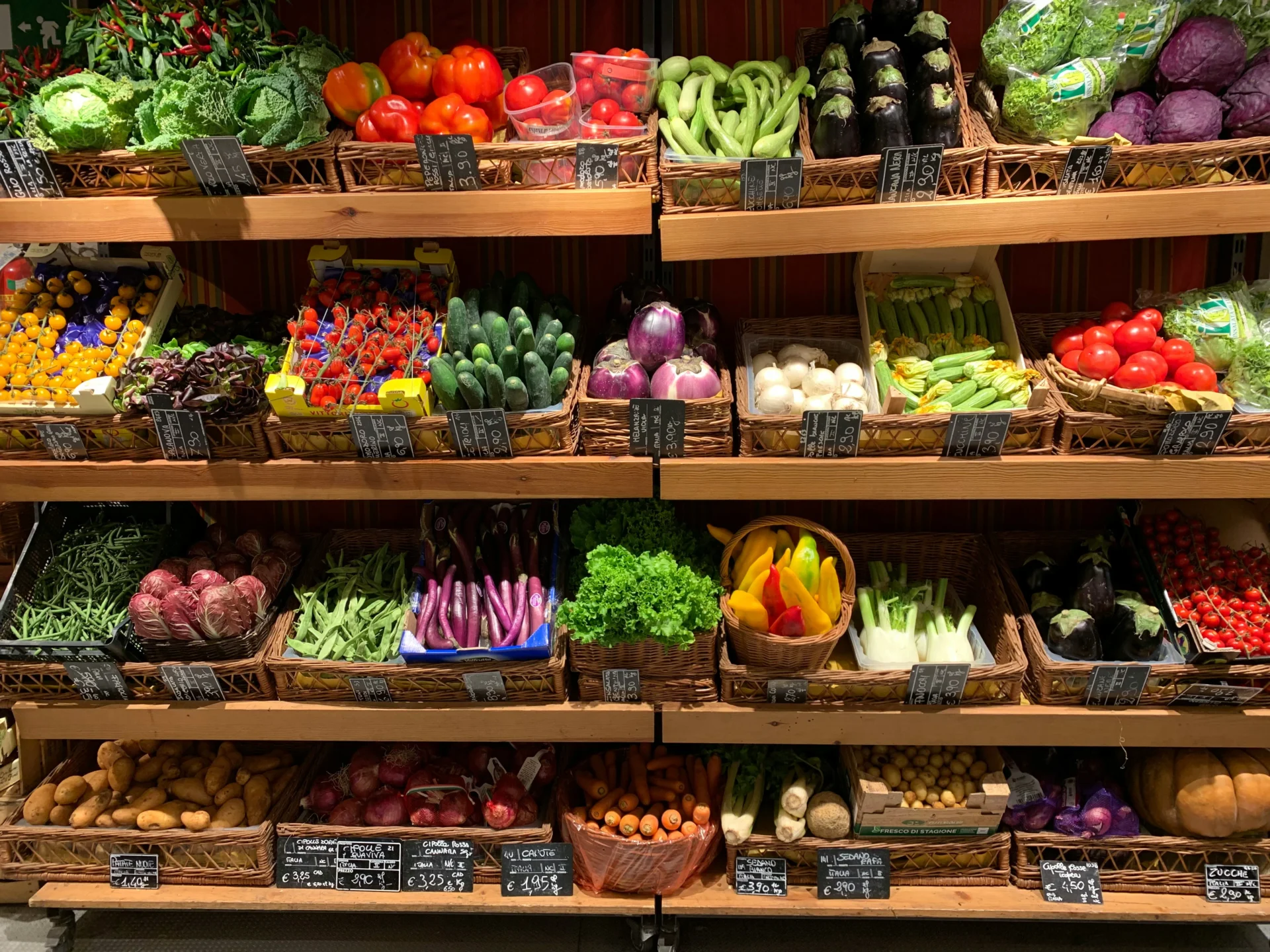 Assortment of fresh organic vegetables displayed in baskets on wooden shelves, showcasing a variety of produce for an organic food marketing strategy.