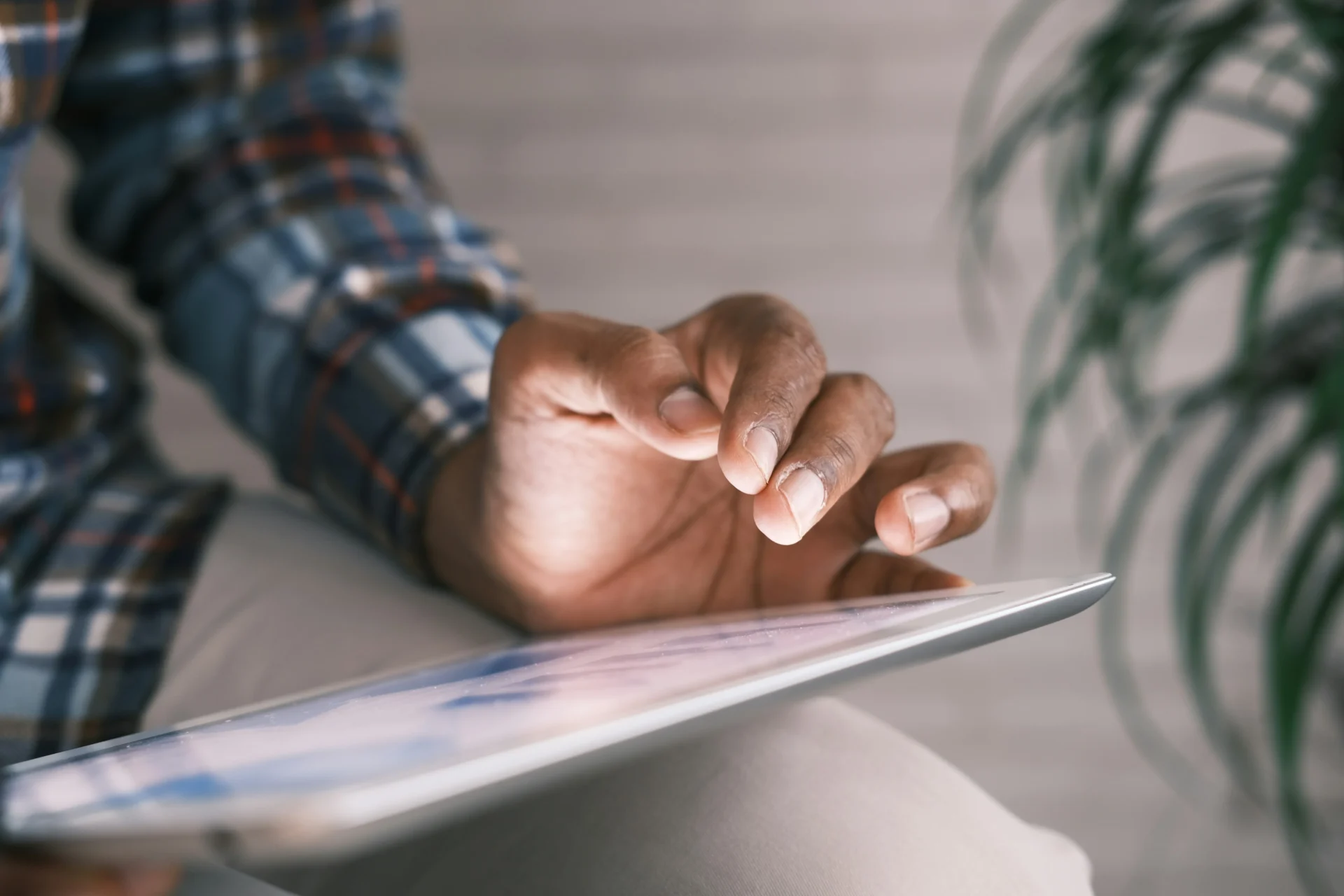 Close-up of a man's hands on a tablet, illustrating digital analysis for internal linking strategy.