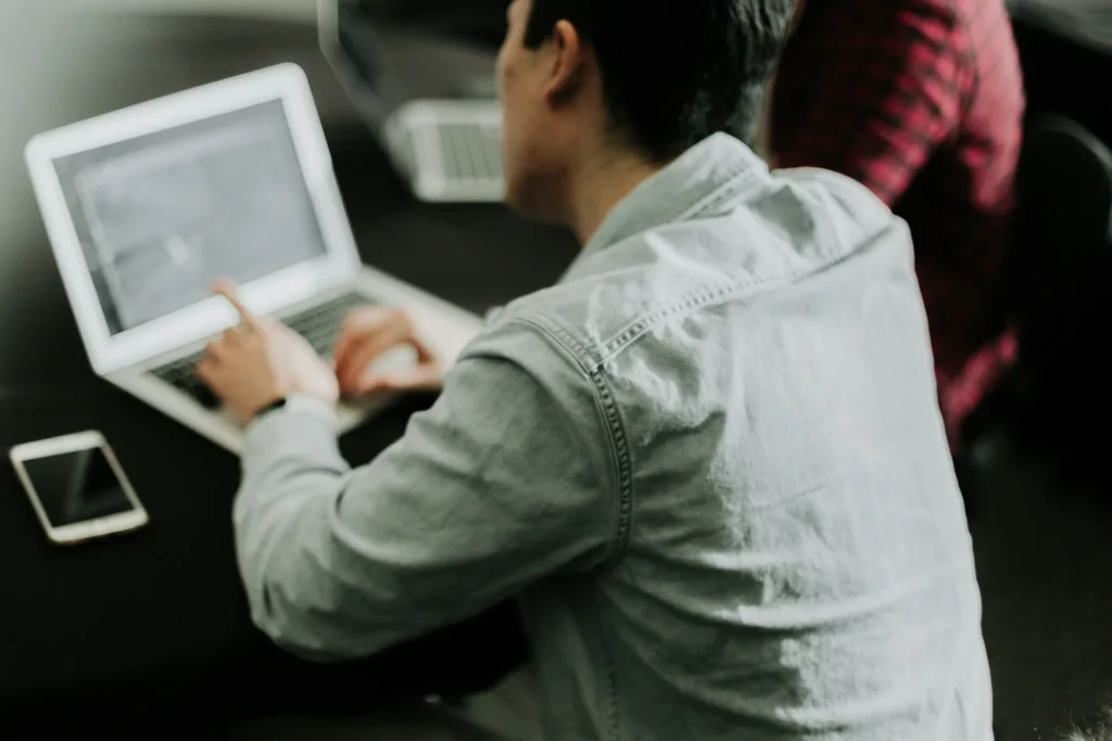 Marketing specialist working on a laptop, possibly conducting sentiment analysis.