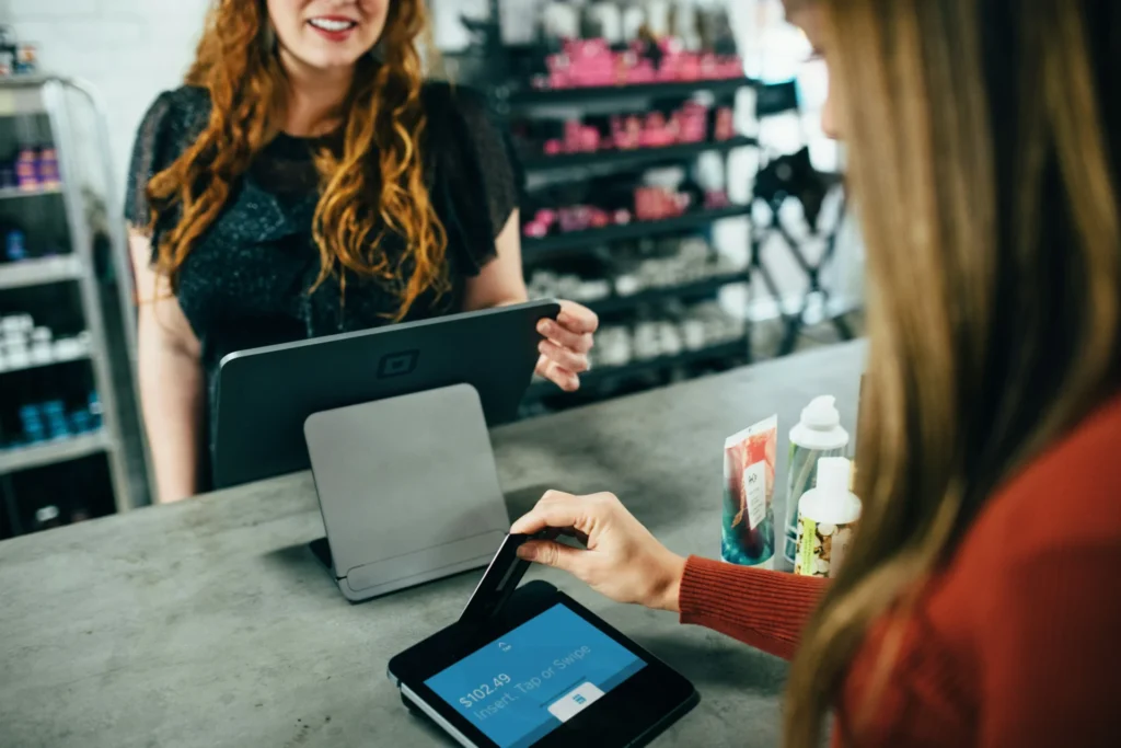 Customer using a credit card at a point-of-sale system, relevant to consumer behavior research on purchasing decisions.
