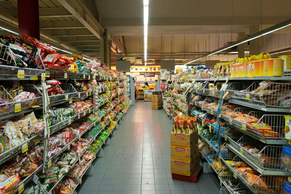 Supermarket aisle with diverse consumer packaged goods (CPG) on shelves, illustrating what is a CPG brand.