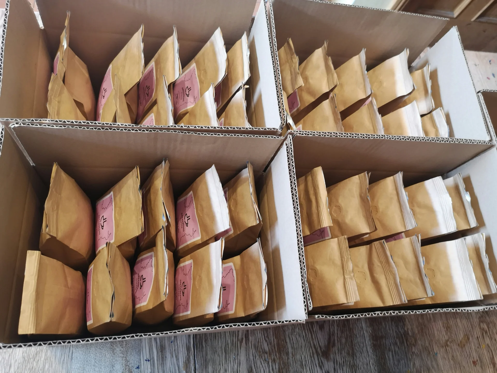 Rows of products in brown kraft paper bags, packed in cardboard boxes, showcasing sustainable packaging design.