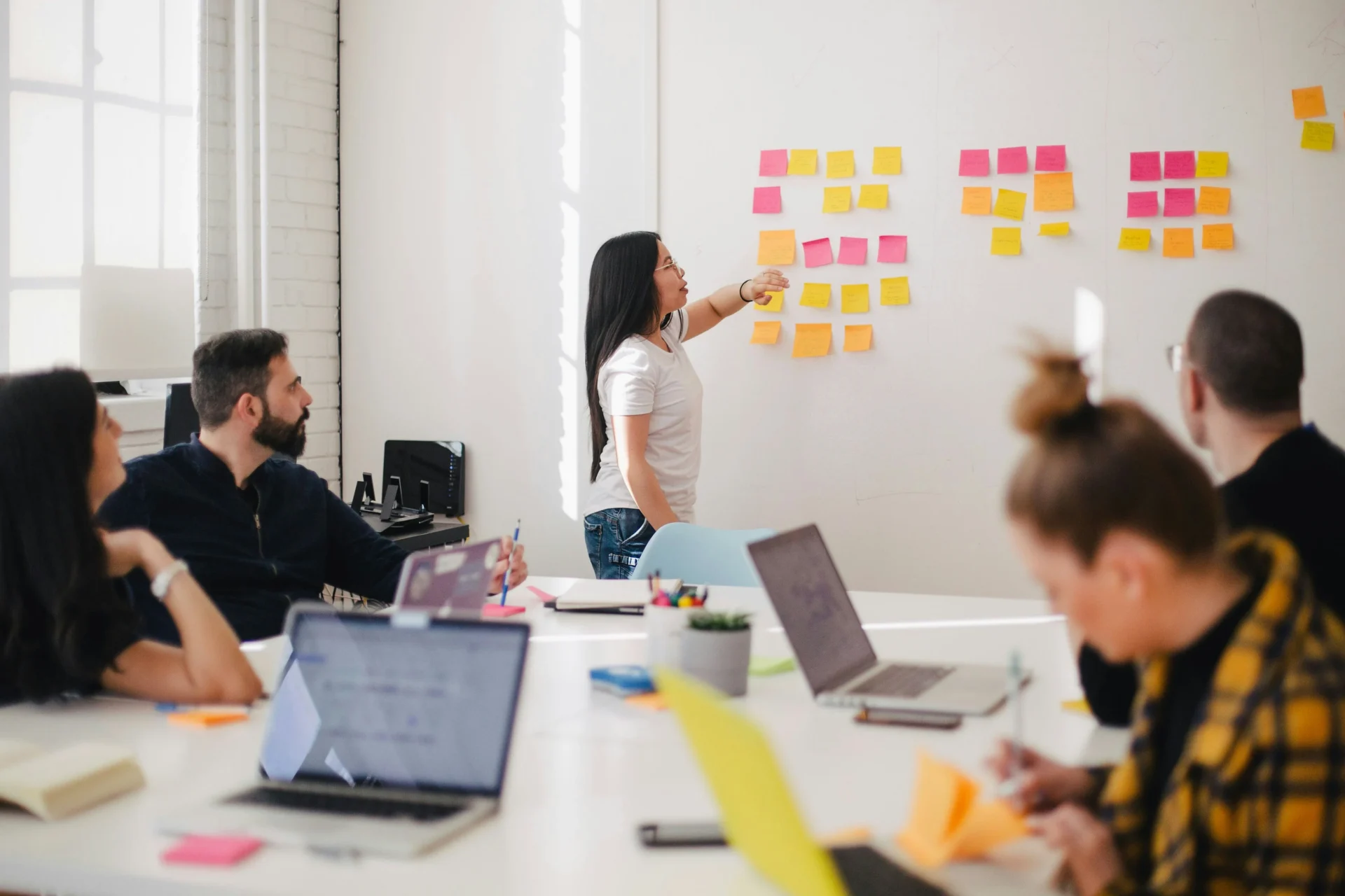 A marketing team collaborating in a workshop, using sticky notes on a whiteboard to plan a national SEO campaign.