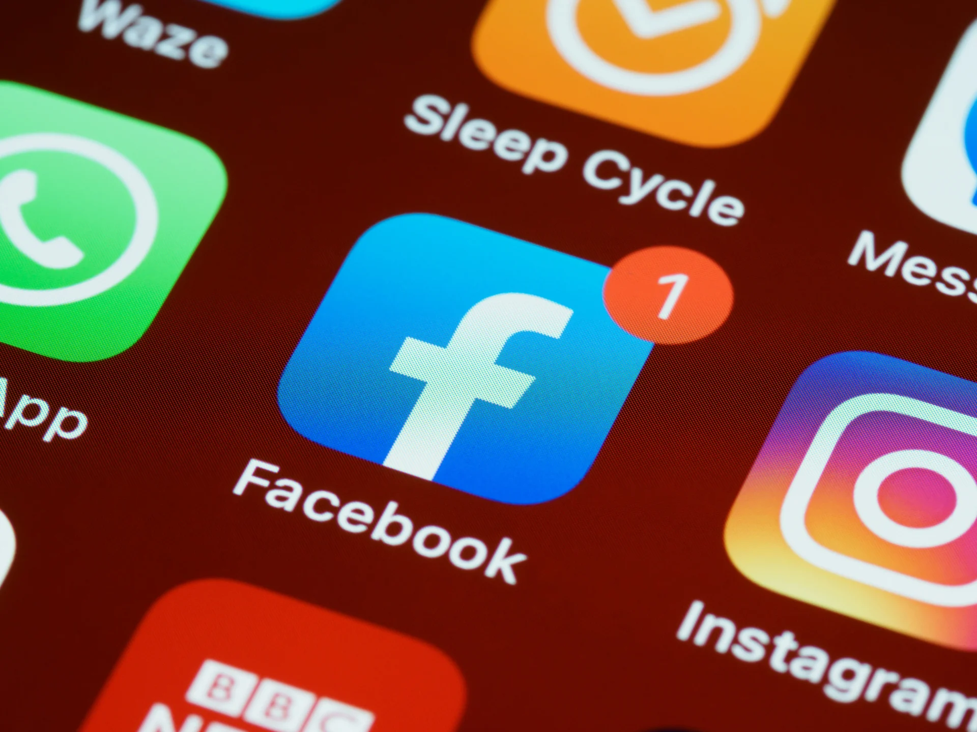 Close-up of phone screen showing Facebook, Instagram, and other app icons, highlighting the importance of utilizing Facebook for business.