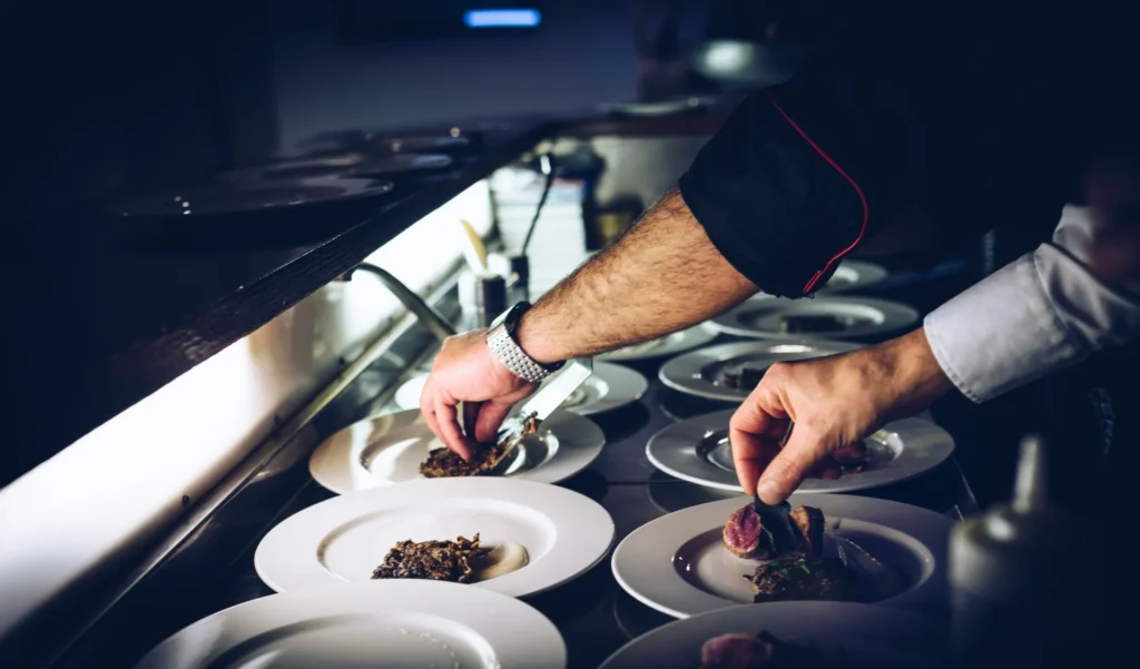 Chefs plating gourmet dishes in a professional kitchen, optimizing for search engine optimization for restaurants.