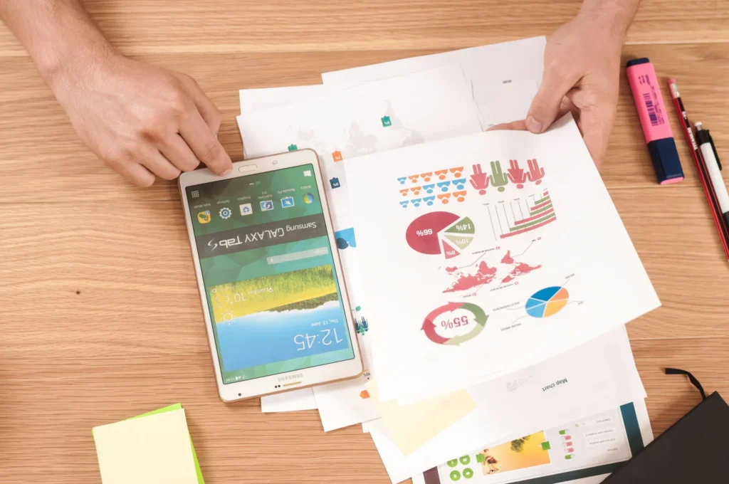 Hands holding a Samsung tablet and reviewing charts and graphs, representing data analysis for an International SEO checklist.
