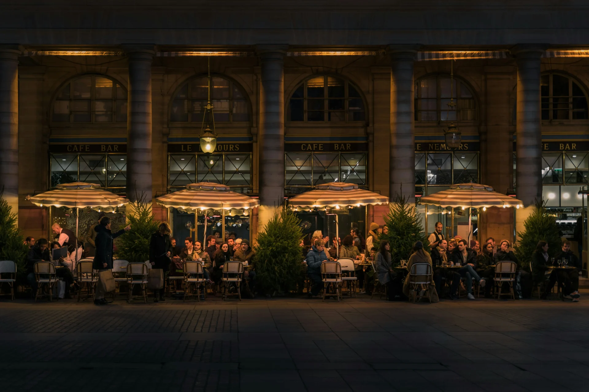 Illuminated outdoor cafe patio at night, showcasing an inviting ambiance for search engine optimization for restaurants.