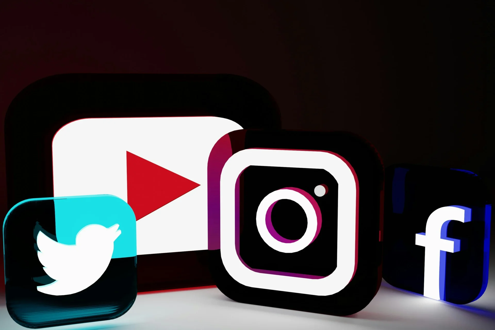 Glowing 3D social media logos for Twitter, YouTube, Instagram, and Facebook, representing how to increase social media engagement.
