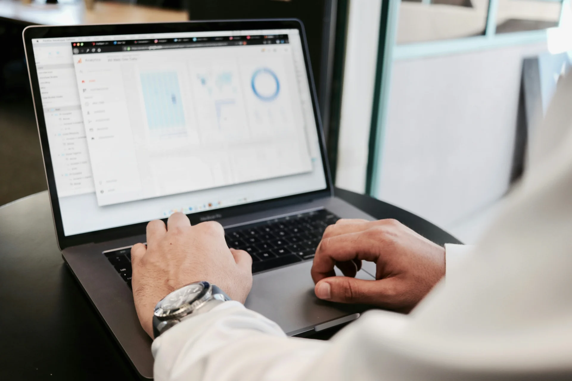 Hands on laptop analyzing data, with charts on screen for building backlinks for SEO.