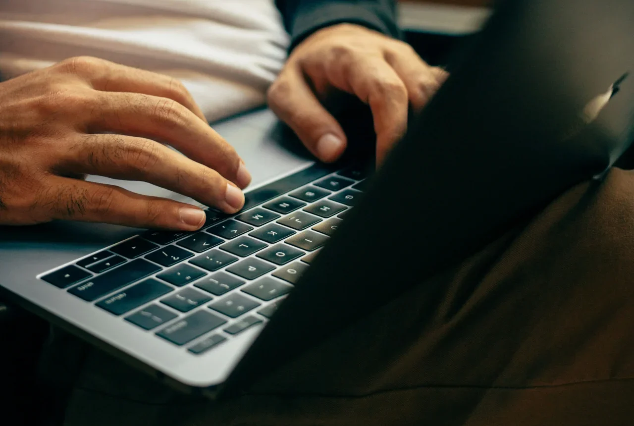 Hands typing on a laptop keyboard, representing the digital work involved in understanding the importance of backlinks.