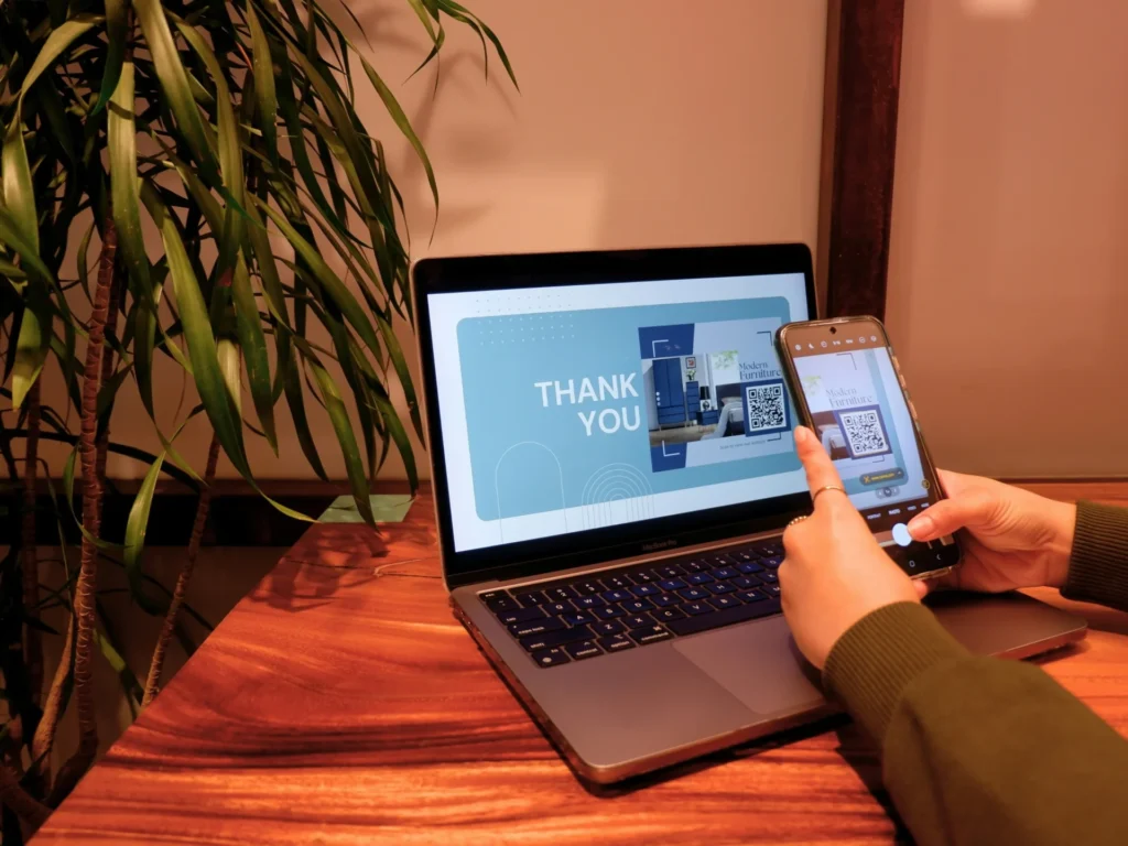 A person scanning a QR code on a laptop screen with a smartphone, an idea for interactive content for funny engagement posts for Facebook.