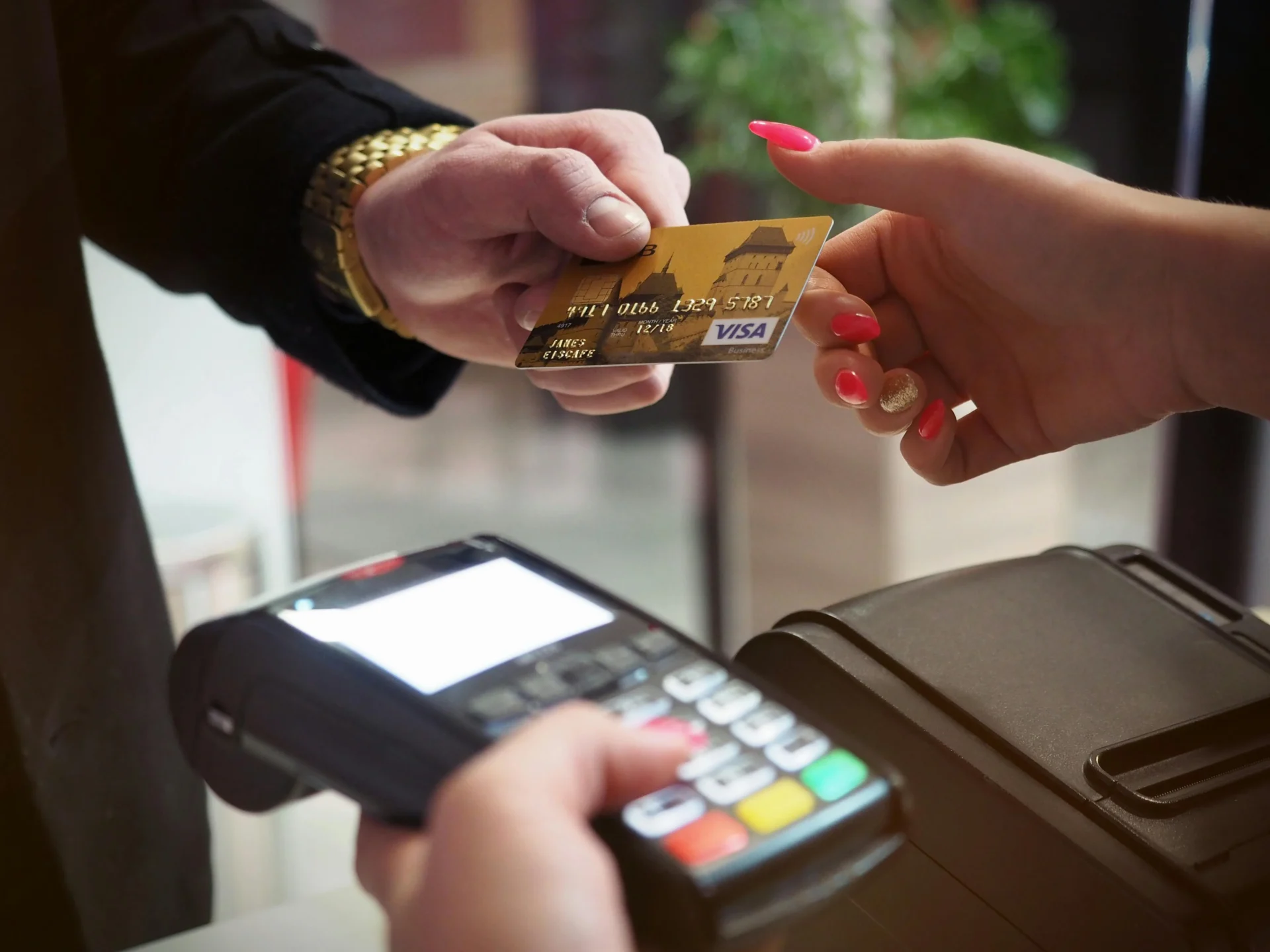 A credit card is used for a transaction at a point-of-sale terminal, a key moment for collecting data that informs CPG consumer insights.