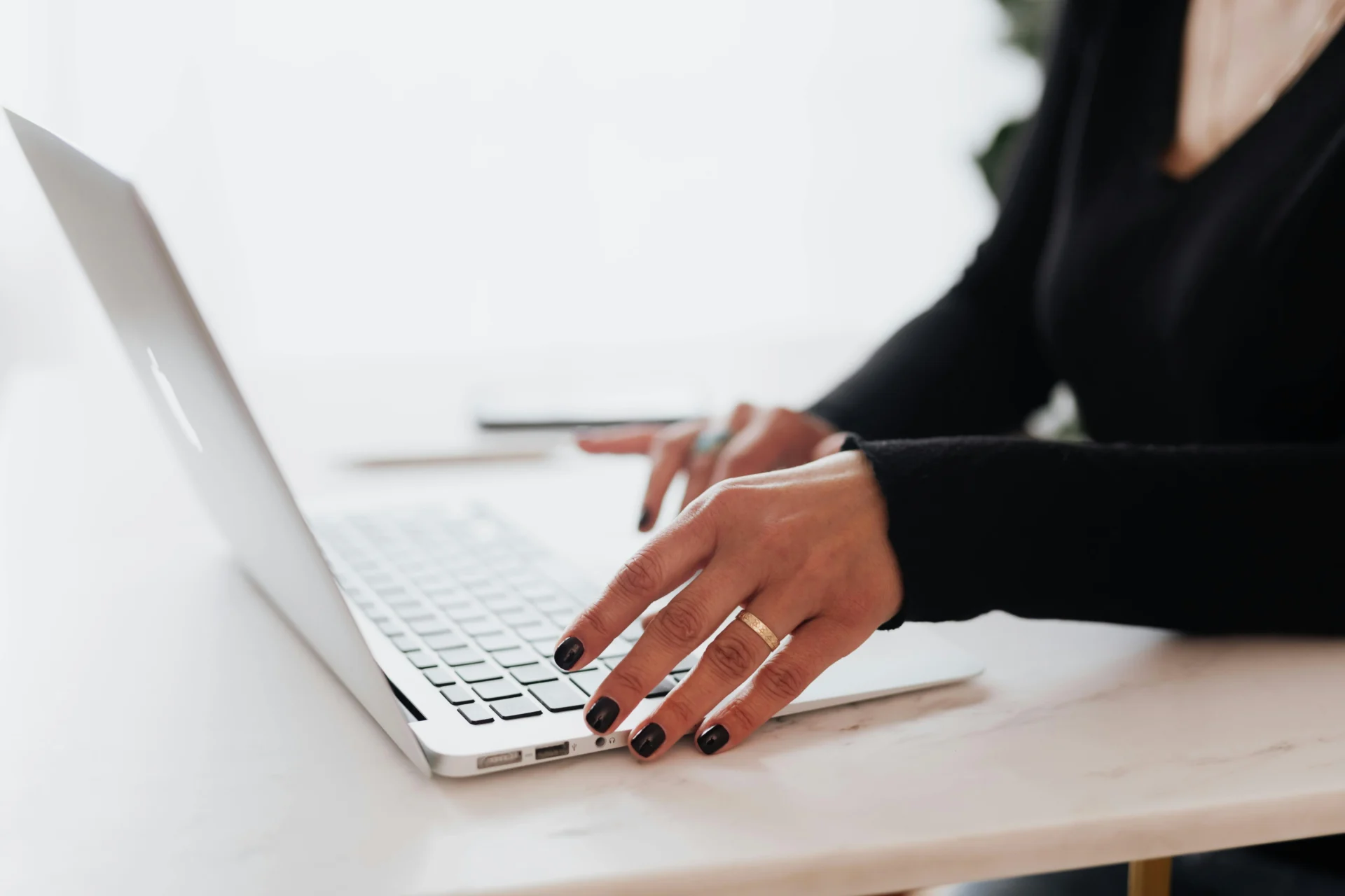 A person reviews analytics on a laptop, taking notes while planning a digital marketing for tech companies campaign.