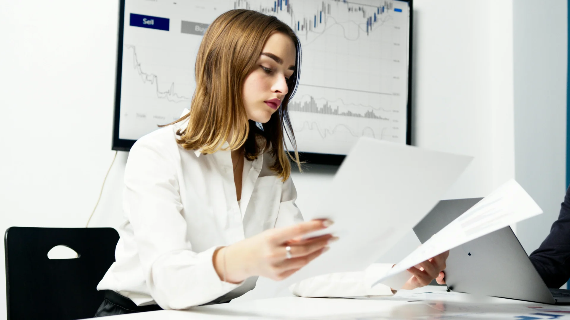 Businesswoman reviewing documents in an office, using data to determine how to find web traffic.