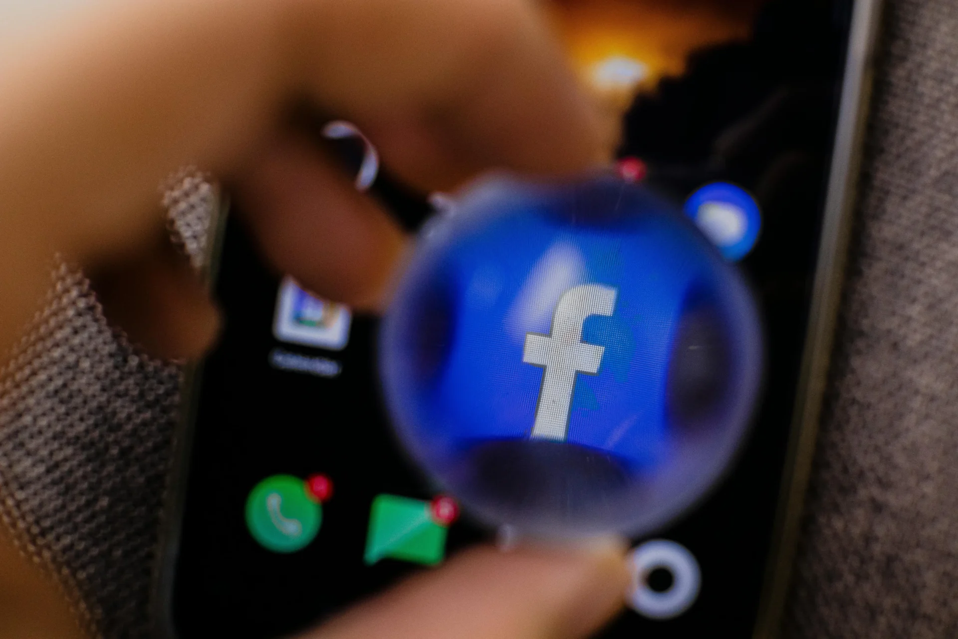 Close-up of the Facebook app icon magnified on a smartphone, representing the concept of a Facebook shadow ban.