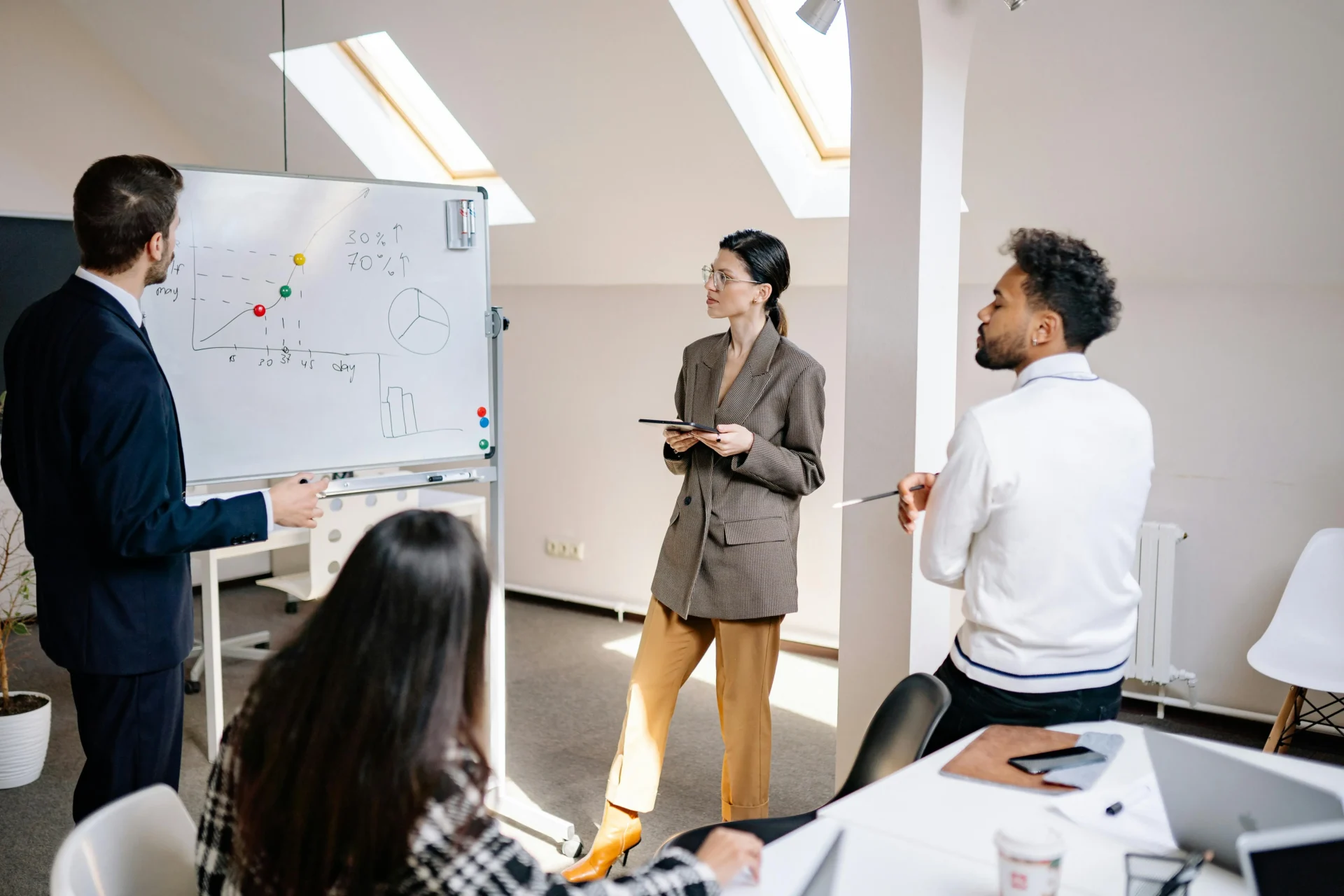 A professional team in an office setting discussing a whiteboard with charts and graphs related to semantic search concepts.