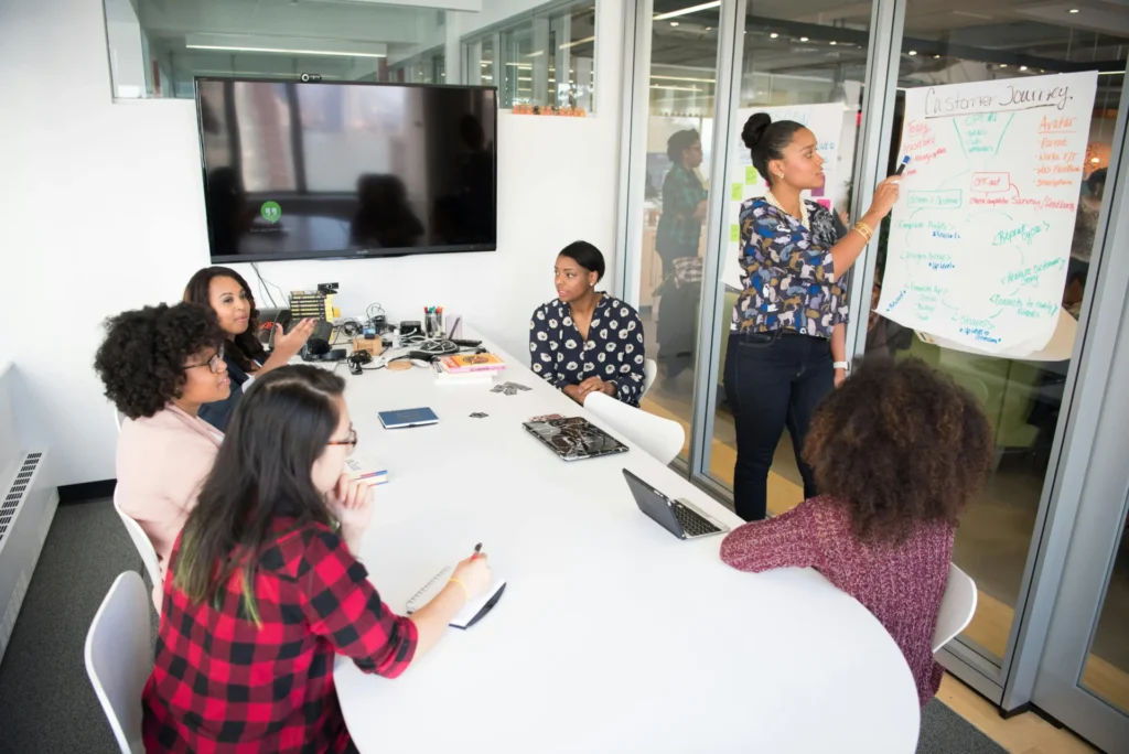 Marketing professional presenting a customer journey diagram during a team meeting about a multi stakeholder marketing strategy