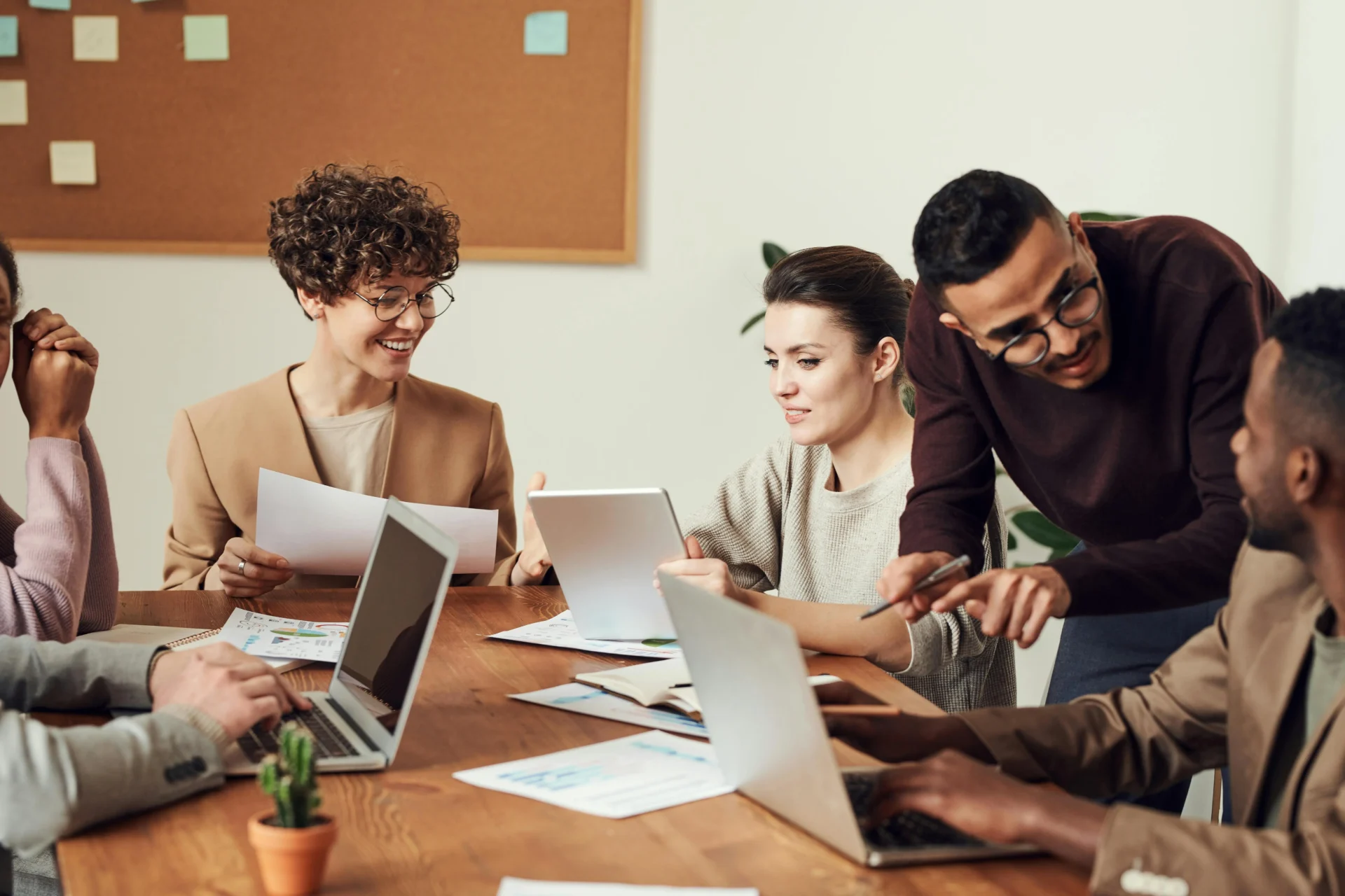 Marketing team collaborating on laptops during a strategy meeting about avoiding internal keyword competition in SEO content planning.