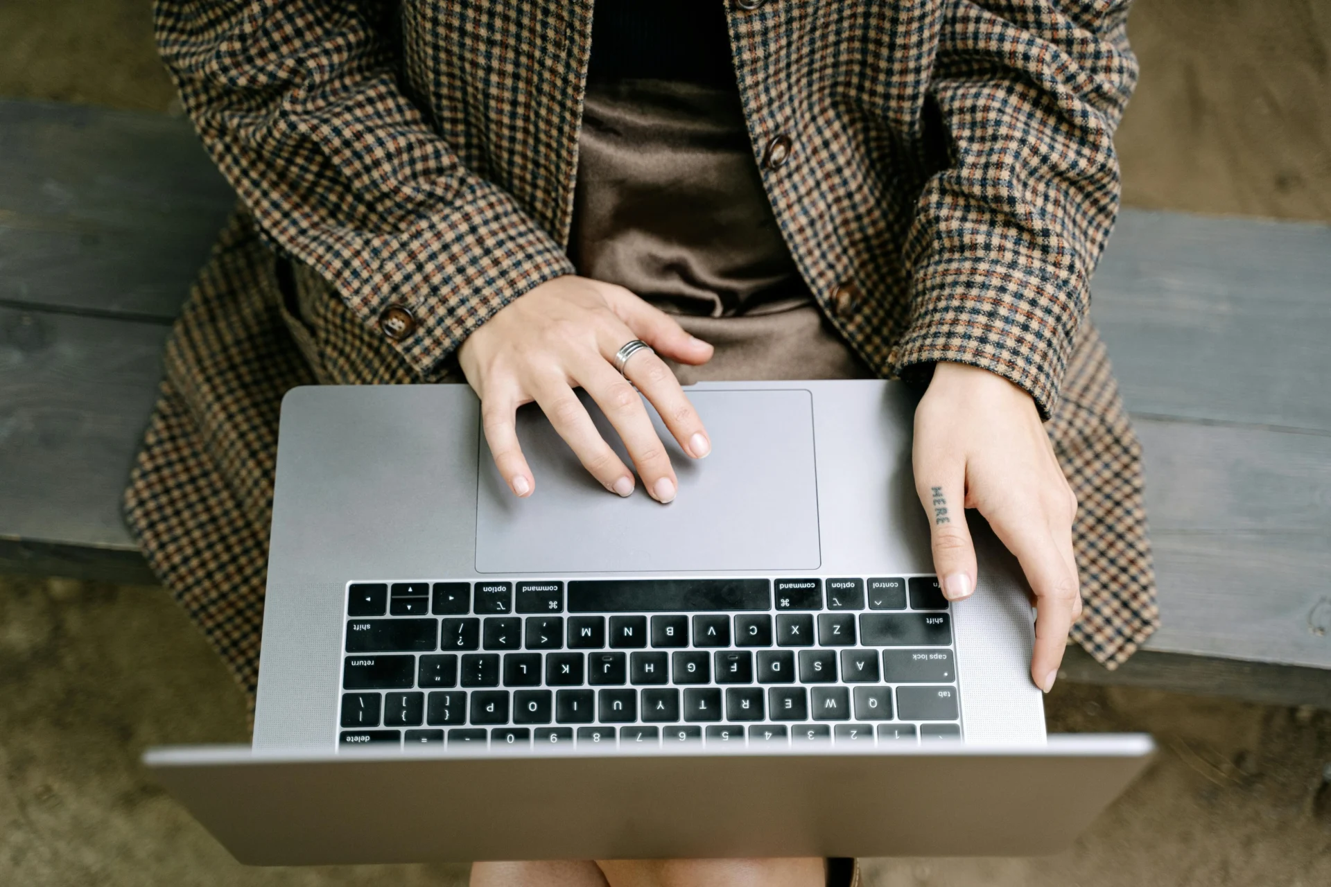 Close-up of hands typing on a laptop outdoors, symbolizing global digital footprint strategy and remote work