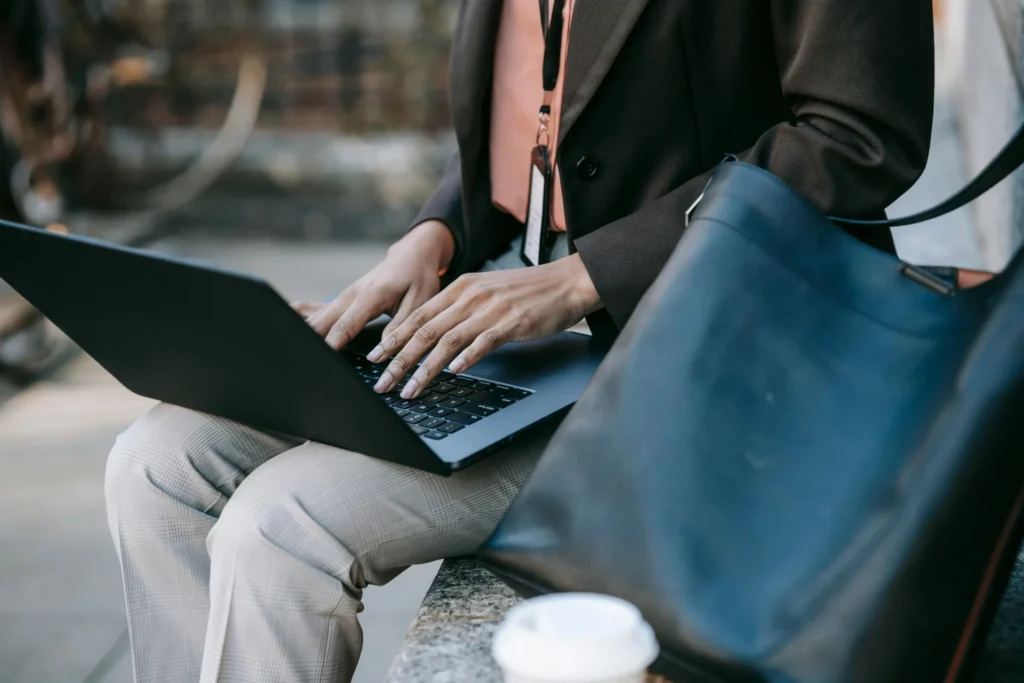 Business professional using laptop outdoors researching local search behavior patterns.