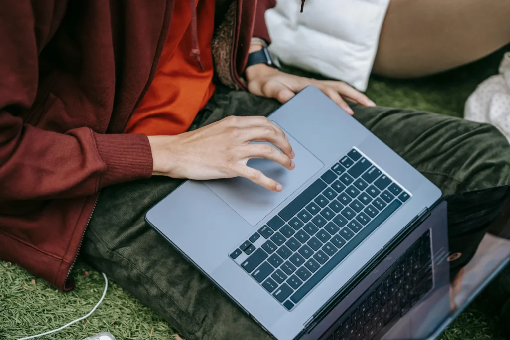 Marketing specialists sitting on grass using laptops to research which AI engines cite sources.