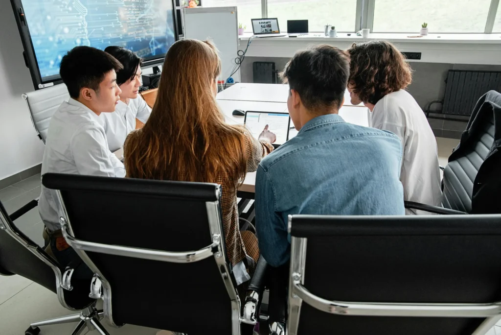 Team reviewing digital content on screen to analyze type of content cited by AI in workspace.