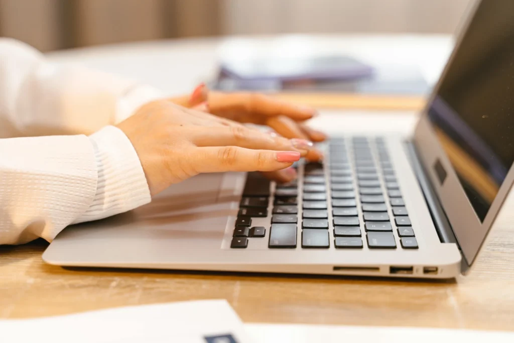 An overhead shot of a person actively using ChatGPT on a dark laptop resting on a patterned mat. A highly relevant visual for articles and guides covering how to see brand visibility in ChatGPT and leverage AI tools for brand monitoring.