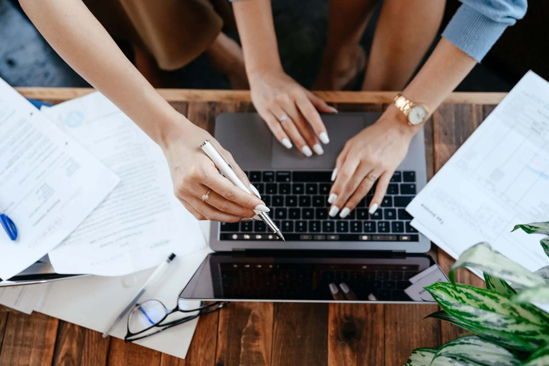 Marketing professional analyzing documents and working on laptop to manage AI search traffic attribution for brand visibility strategy