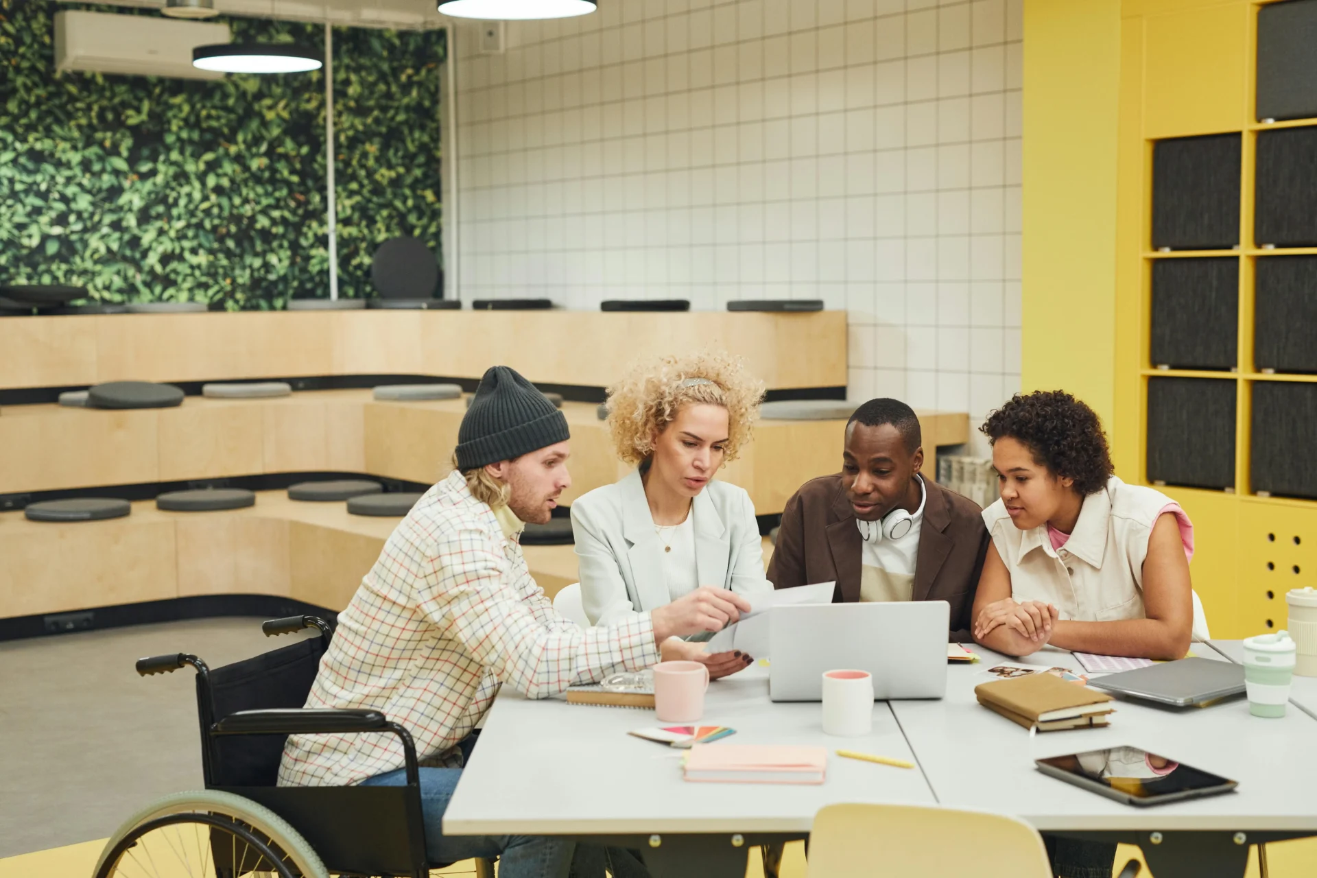 Inclusive and diverse marketing team reviewing brand vs competitor AI mentions data together on a laptop in a modern creative office