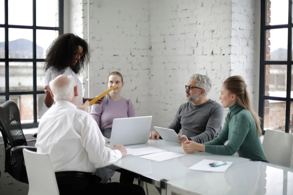 Diverse marketing team collaborating in a modern office meeting to develop AI search traffic attribution strategies for brand visibility