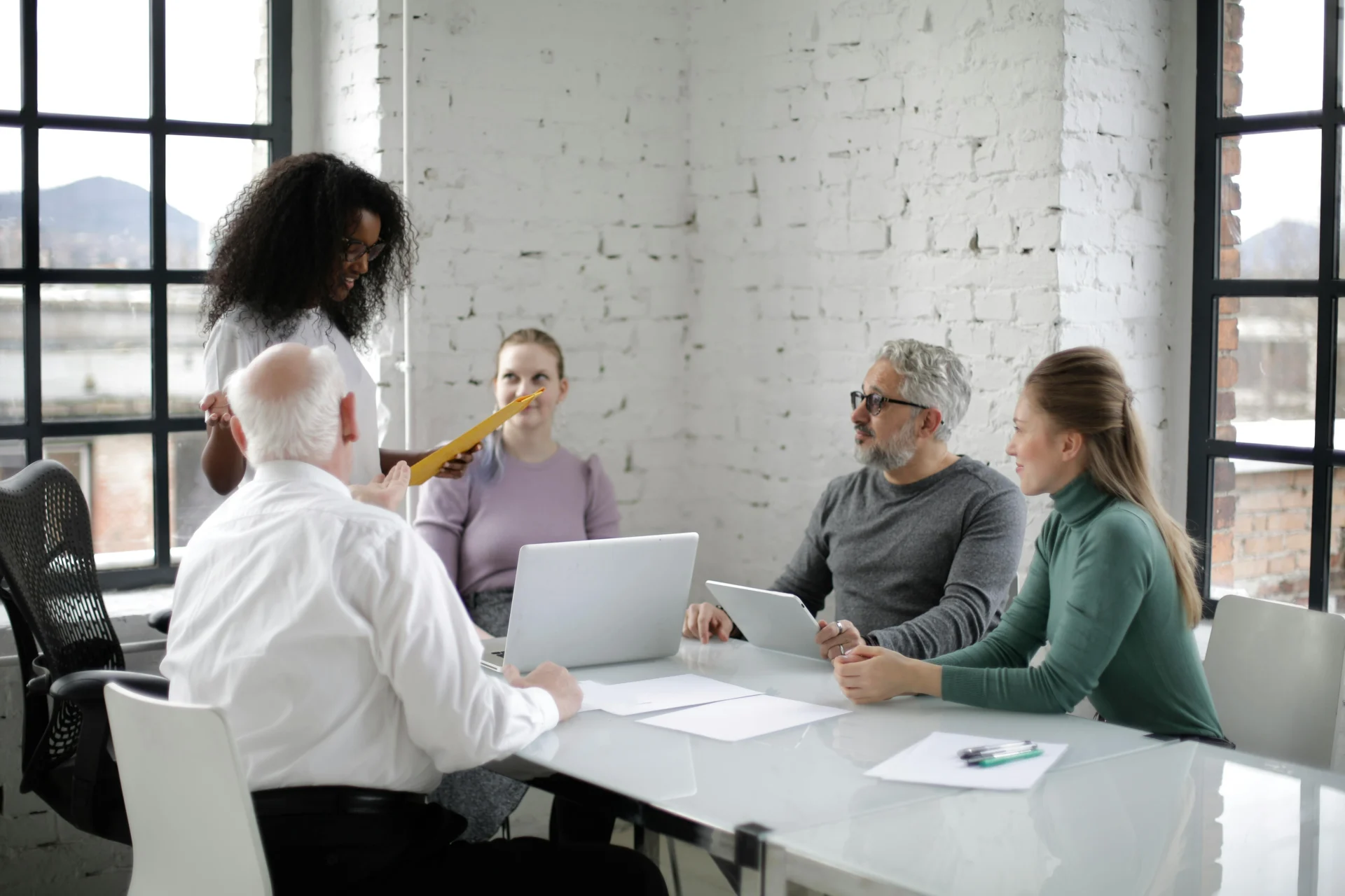 Diverse marketing team collaborating on strategies to improve brand visibility in AI search engines during a modern office meeting