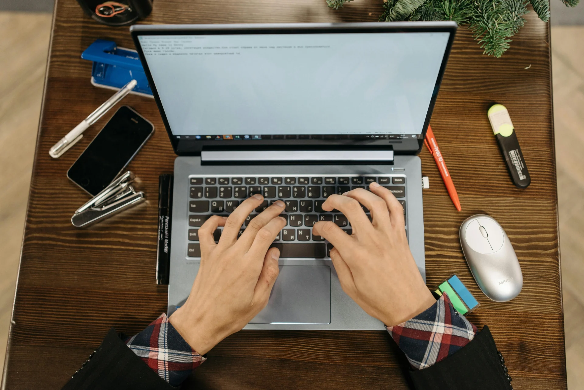 Professional using AI tools for repurposing content on a laptop at an organized wooden desk with office supplies