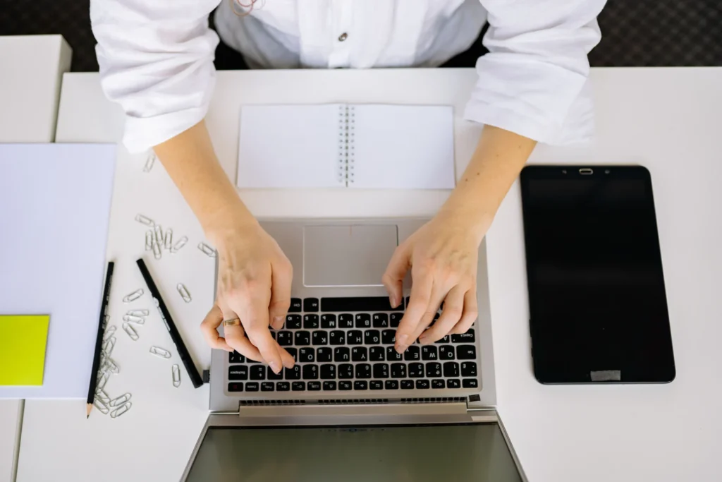 Marketing professional working on AI search optimization prompts at an organized office desk.