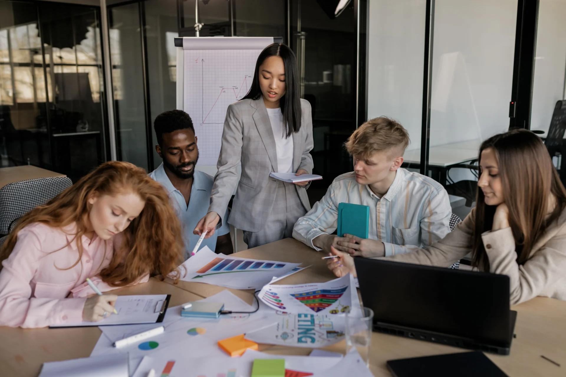 Marketing team collaborating on charts and strategy documents to map AI driven search behavior